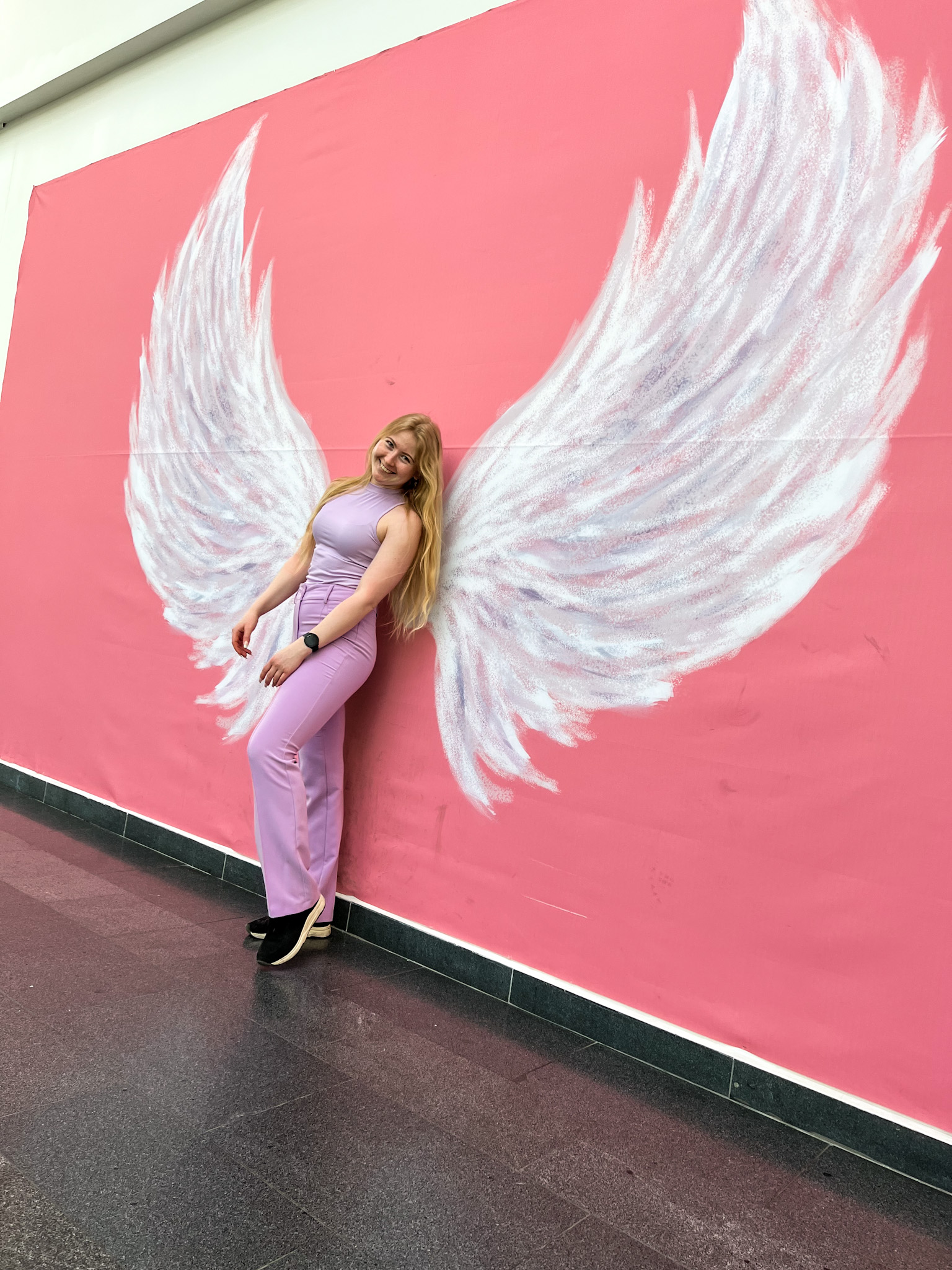 Woman posing in front of angel wings