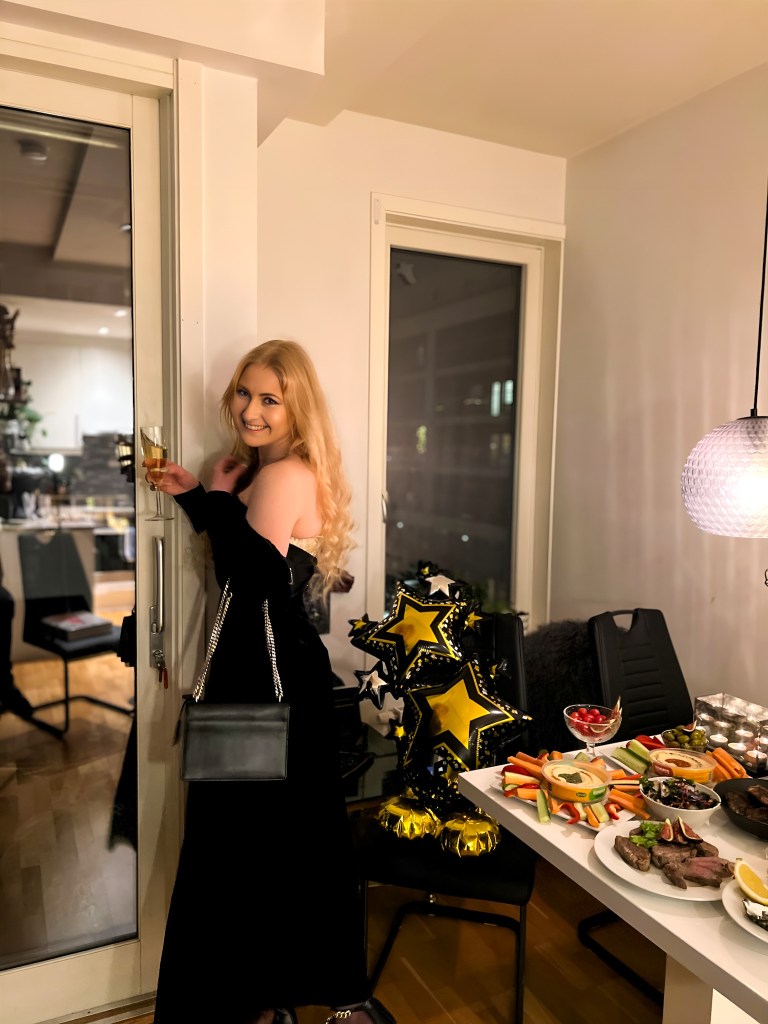 Woman in a black dress at New Years posing to the camera