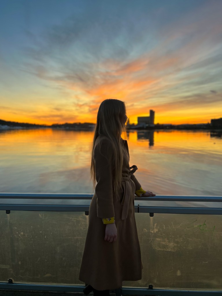 Woman in a coat looking at the sea