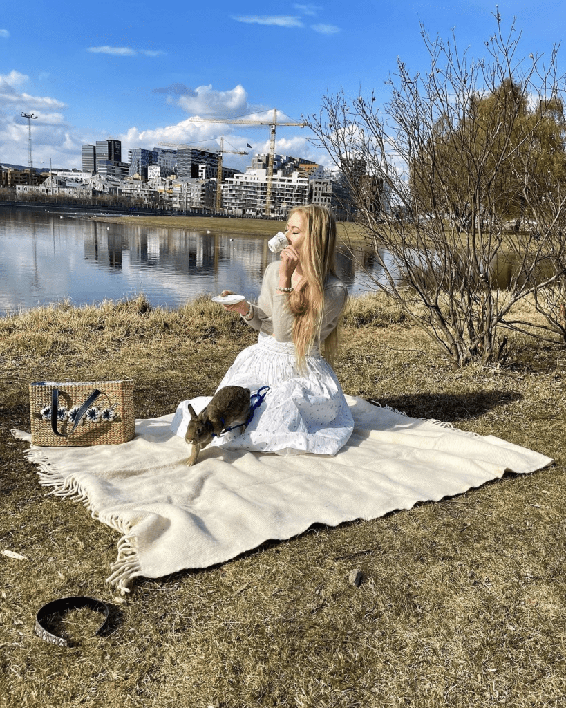 Alice in wonderland photoshoot with a bunny running and a woman drinking tea.