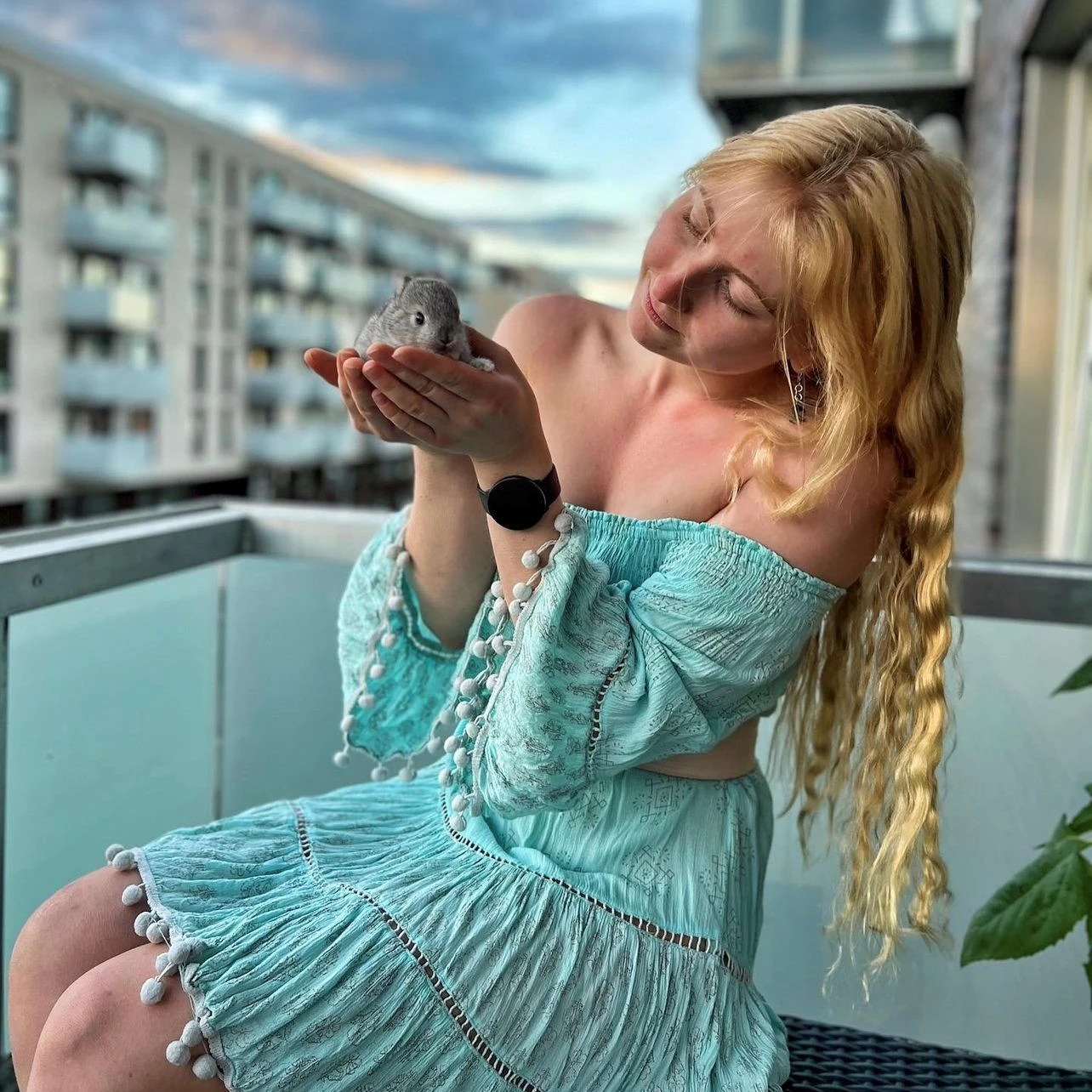 Woman in a turquoise dress holding a baby bunny