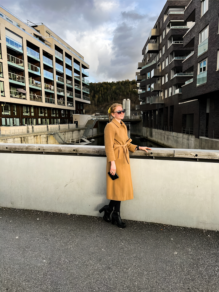 Smiling lady in a coat and high heels