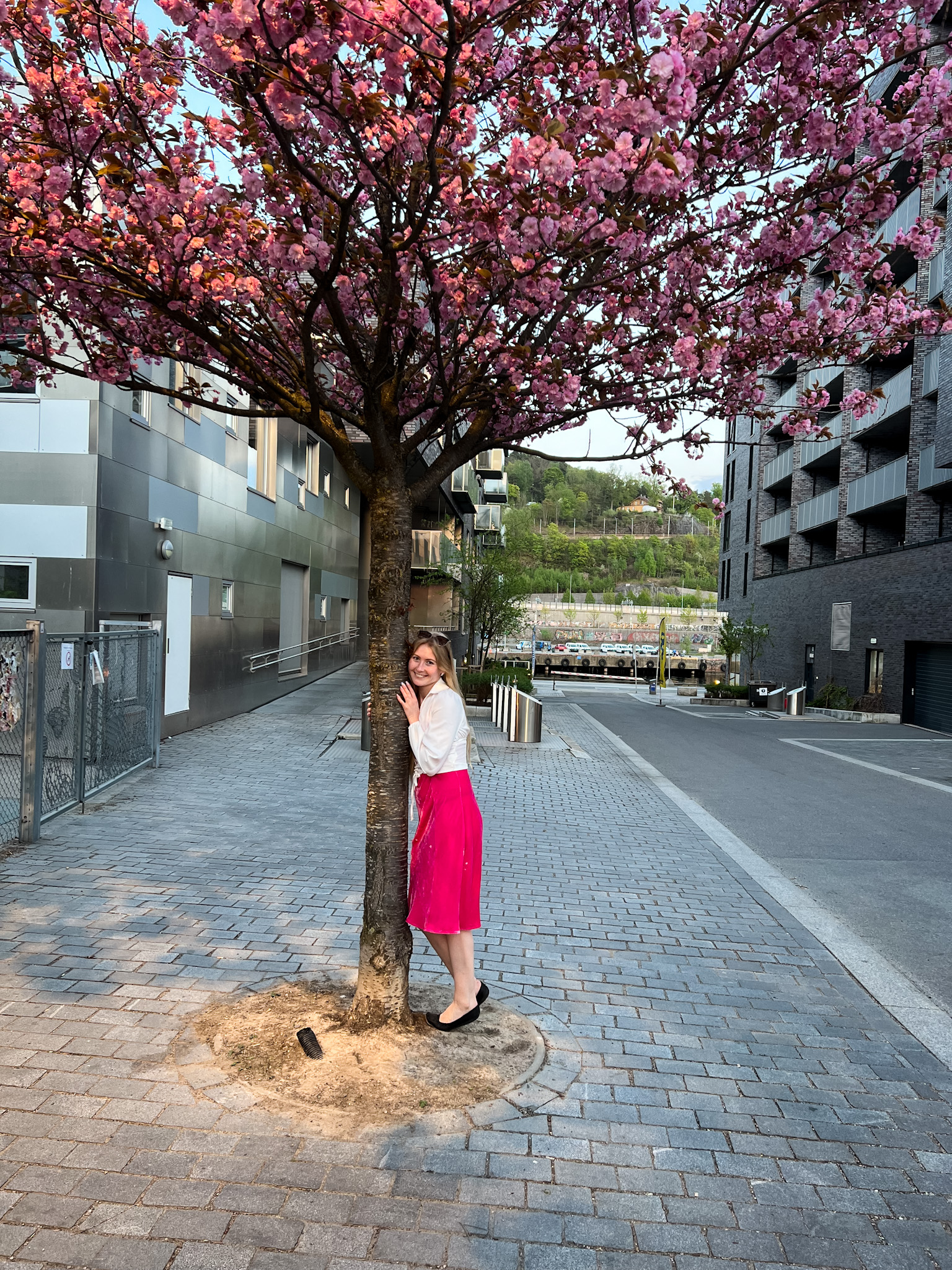 Girl by a pink blossomed tree