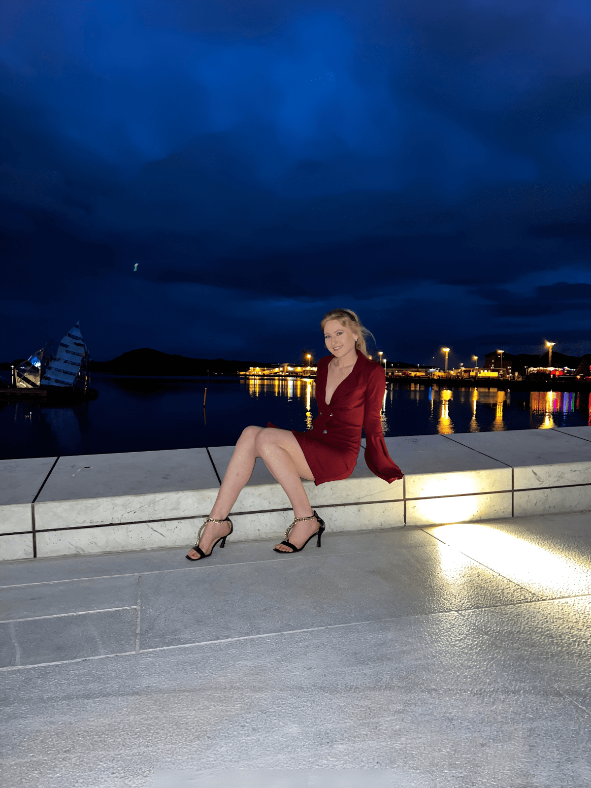 Nighttime with a view, woman in a red dress and heels. Oslo Opera