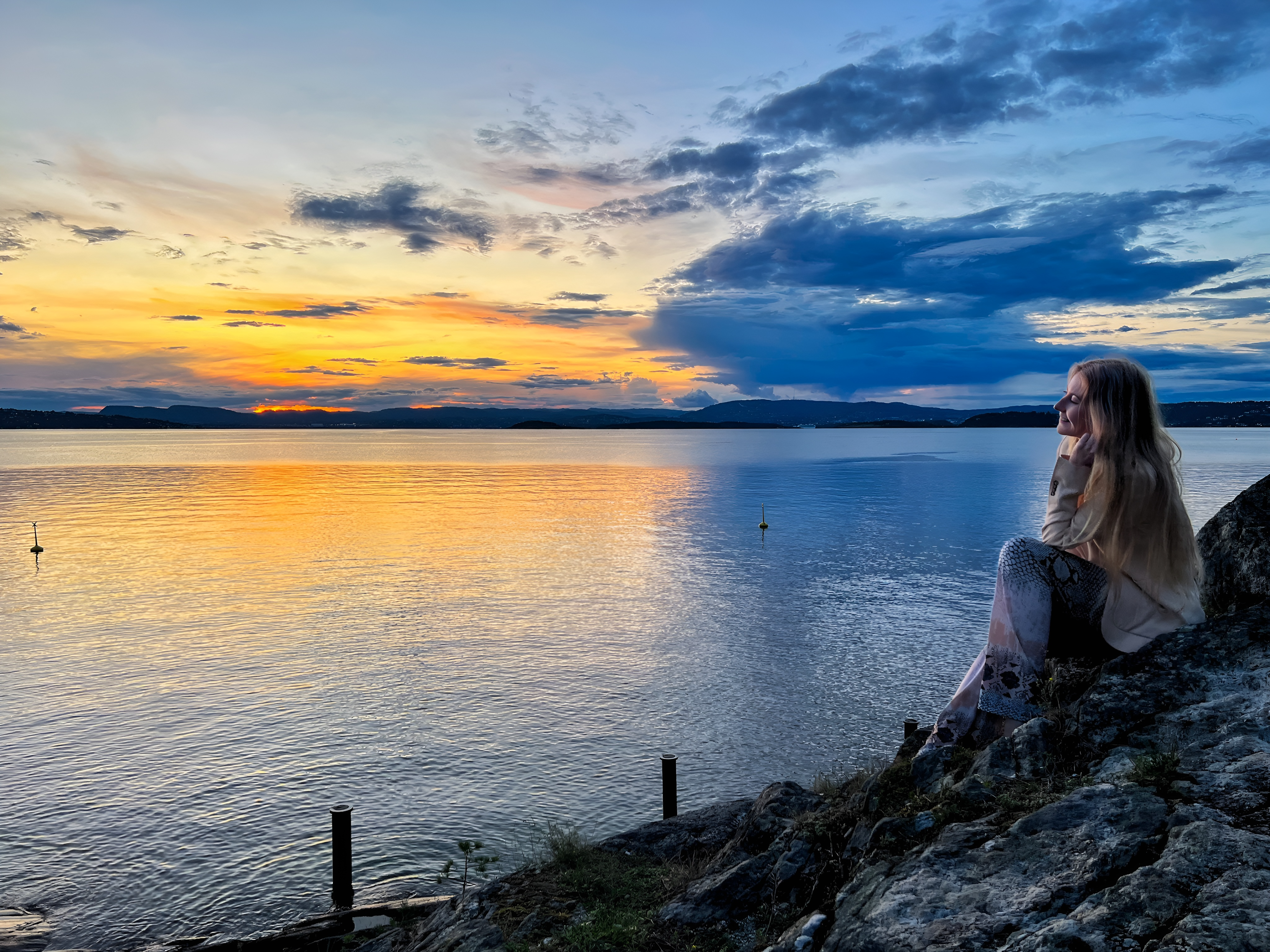 Woman by the sea during sunset hour.