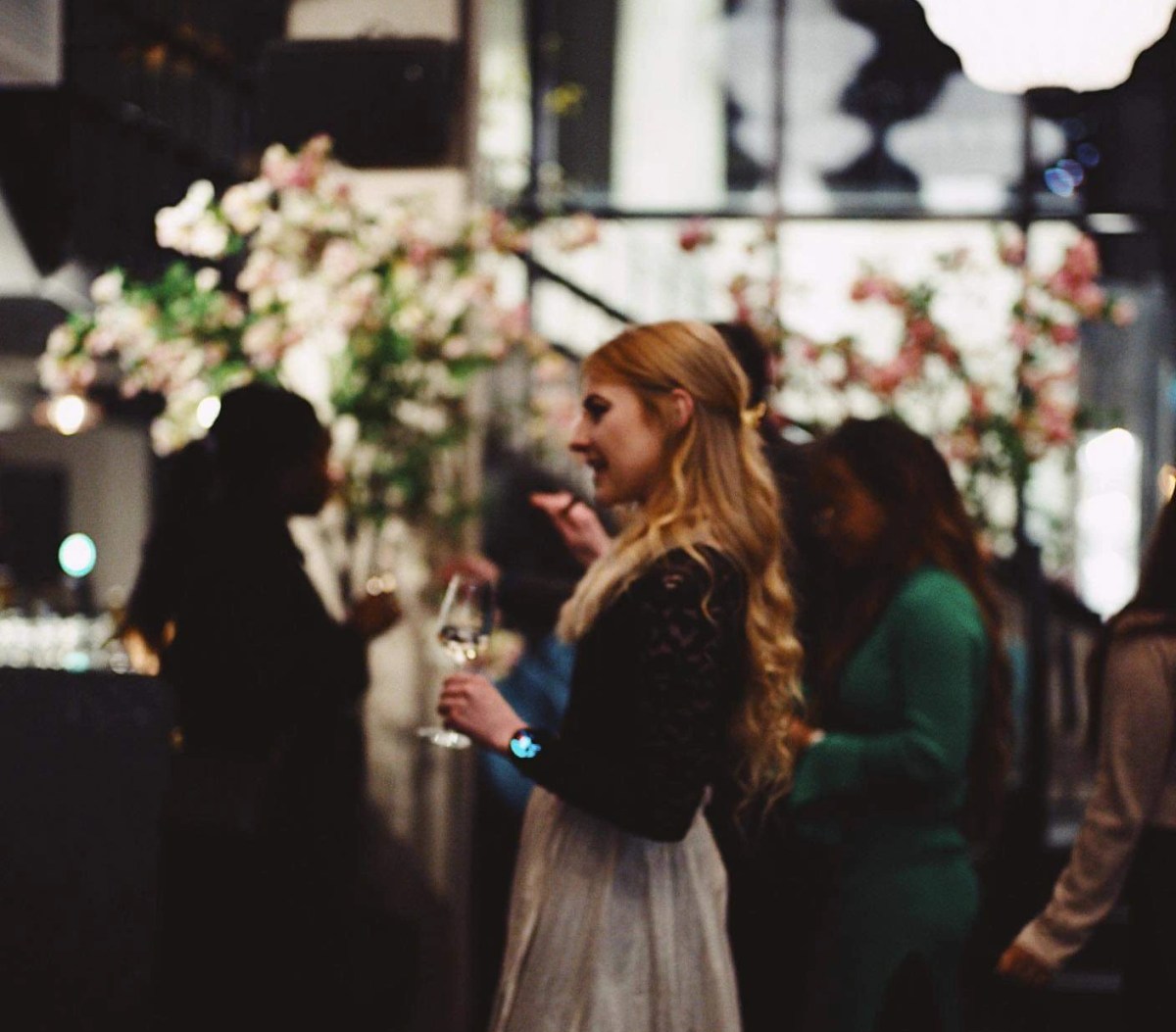 Speech during book launch, blond woman with curls. Black laced sweater and a long skirt.